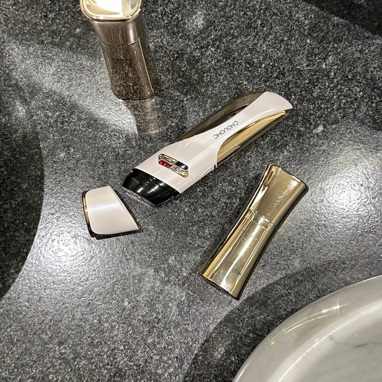 Top-down still image of CHOUCHOU TOKYO Carver series arranged on black marble surface, likely in a bathroom. Sleek, minimal styling reflecting premium beauty tech.