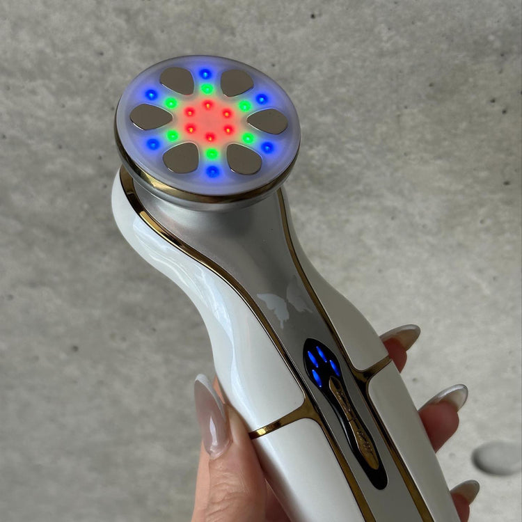 Close-up of a manicured woman’s hand holding CHOUCHOU TOKYO The Morpho beauty device with LED lights activated, showcasing elegant form and advanced tech.