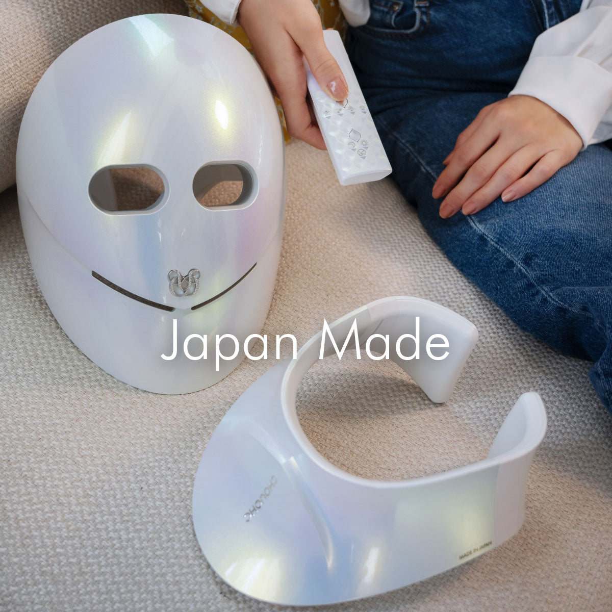 CHOUCHOU TOKYO The Radiance Kit on white sofa with face mask, neck mask, and remote; woman's hand reaching for remote, 'Japan Made' text displayed on image.